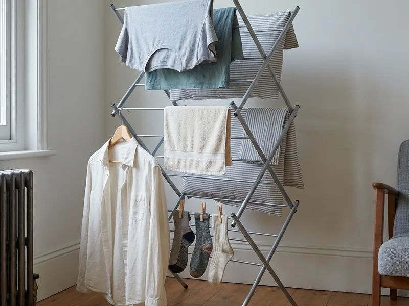 Washing hung on a concertina airer in a bright room