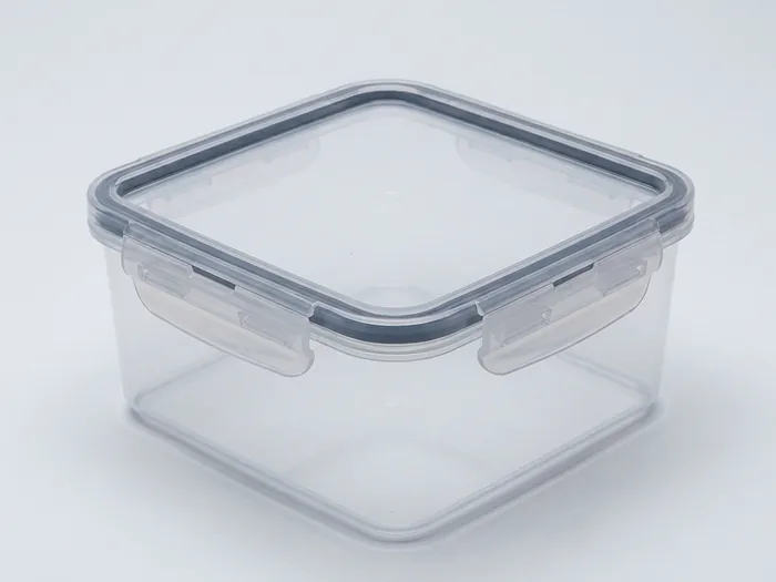 A clear clip-lid storage box holding folded bedding